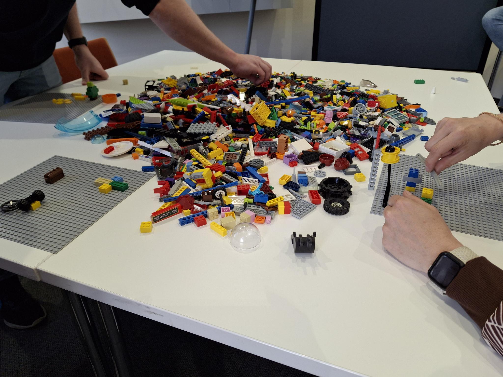 Tisch mit vielen verschiedenen bunten Lego Steinen