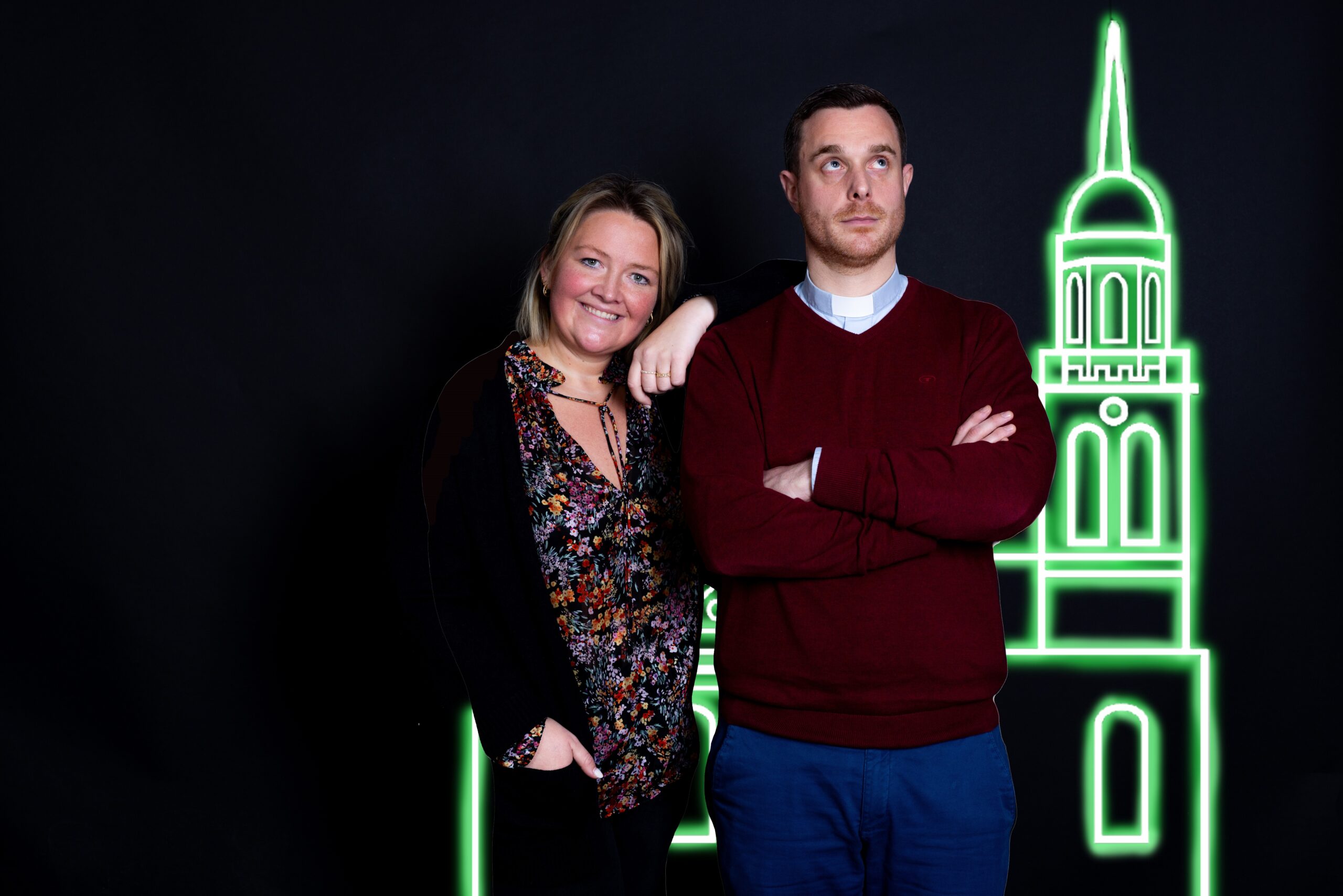 Frengels und Chef vor einem Kirchturm der beleuchtet ist.