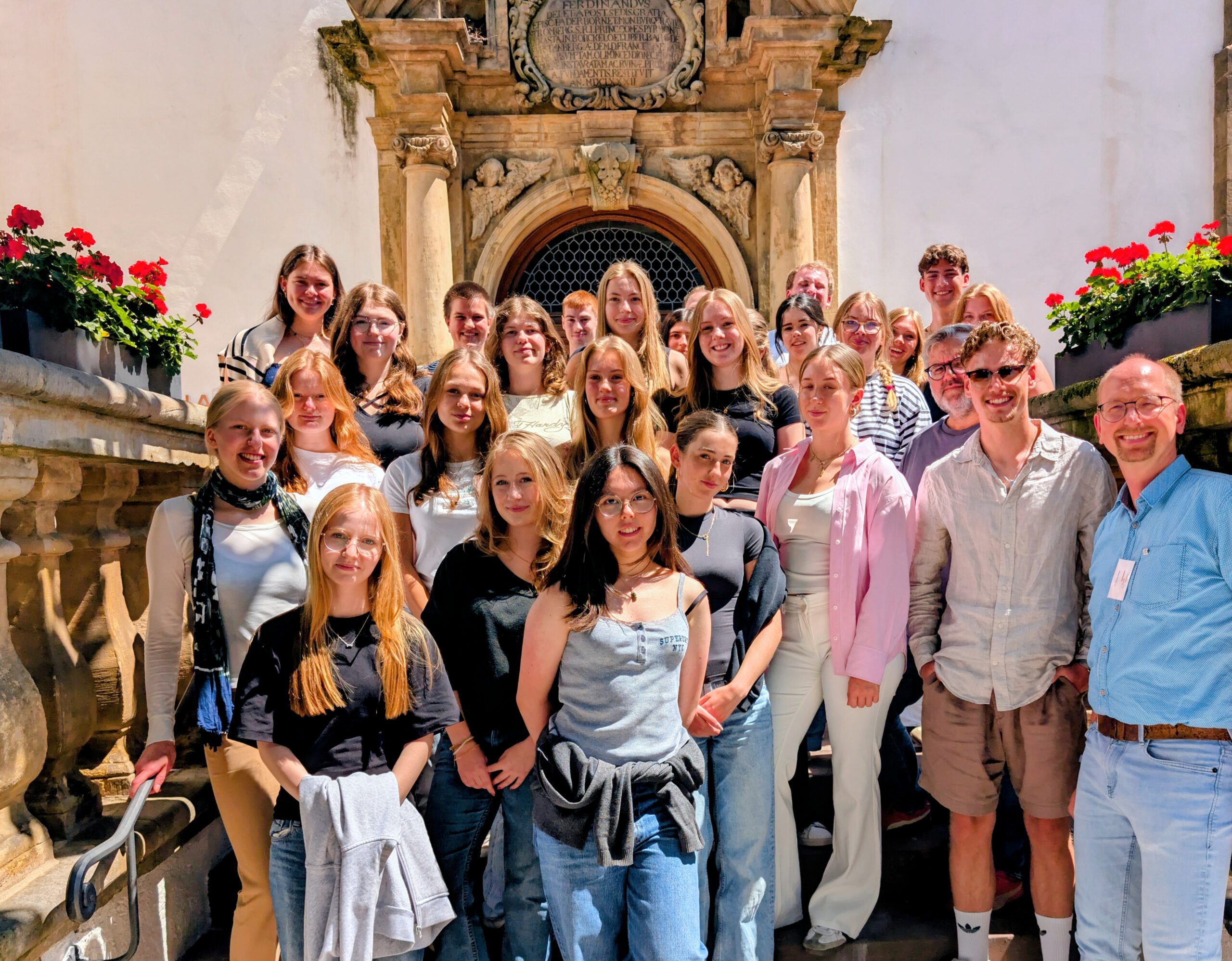 Eine Gruppe von jungen Menschen, die vorm Portal der Kapuzinerkirche stehen.